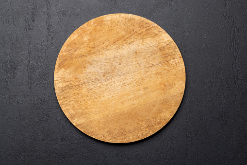 Wooden cutting board on stone kitchen table. Flat lay with copy space