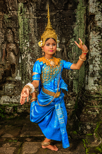 A woman shows Apsara dance in old ruins near Siem Reap, Cambodia.