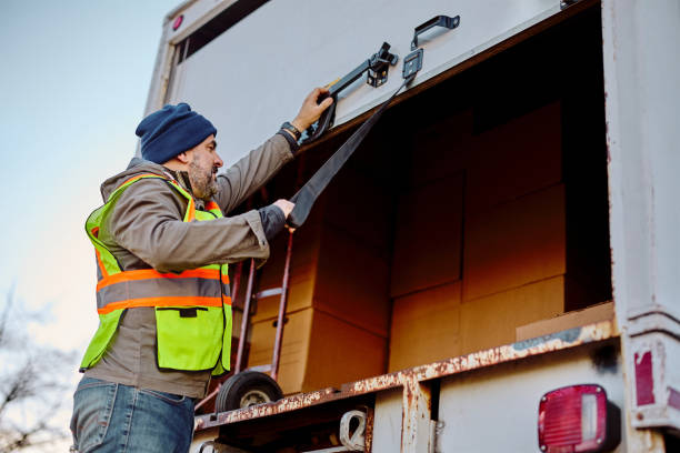 Below view of delivery man closing down the back door of a truck. Low angle view of truck driver closing back door of a vehicle while getting ready for ride. moving van stock pictures, royalty-free photos & images