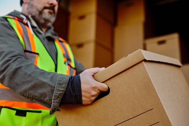 istock Close up of courier unloading cardboard boxes out of delivery van. 1472119590