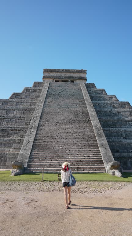 Woman on the background of Chichen Itza pyramid in Mexico