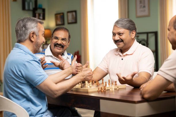 istock Two senior men playing chess while their friends watching them. Stock photo 1472123280