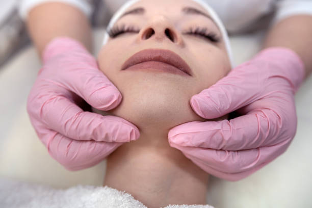 istock Young woman receive face massage at spa salon 1472125611