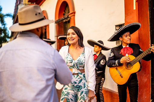 Mid adult couple dancing mariachi music at the historic district