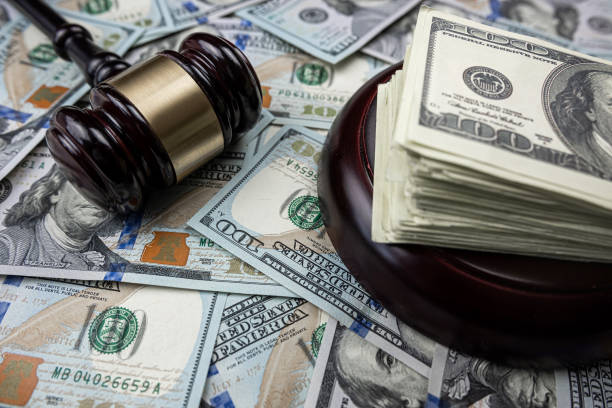 istock Judge's hammer lying on 100 new dollar money 1472127750