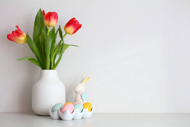 istock Vase of tulips, Easter bunny, Easter eggs on white wall background. Happy Easter concept. 1472128996