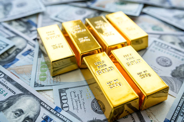 istock 100 dollar bill with gold bars as finance background 1472129392
