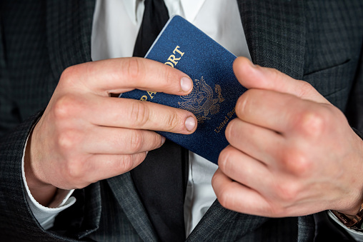 business man wear suit holding USA  passport.