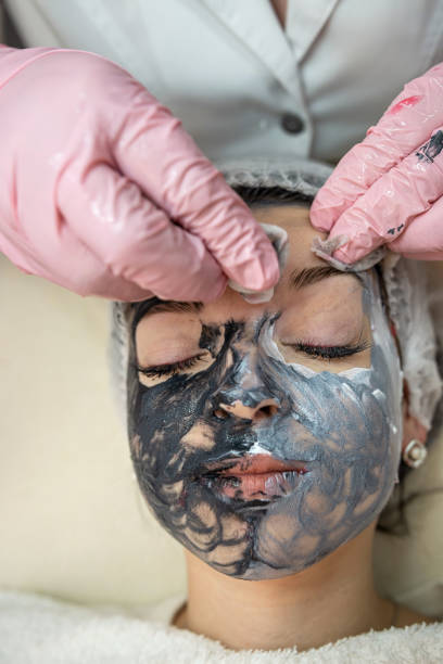 istock hands of a cosmetologist massage a face on which a mask is applied 1472131948