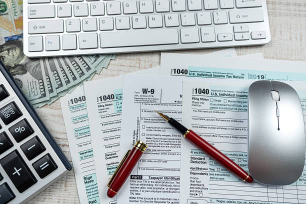 istock 2022 blank tax form 1040 with us dollar biils 1472132103