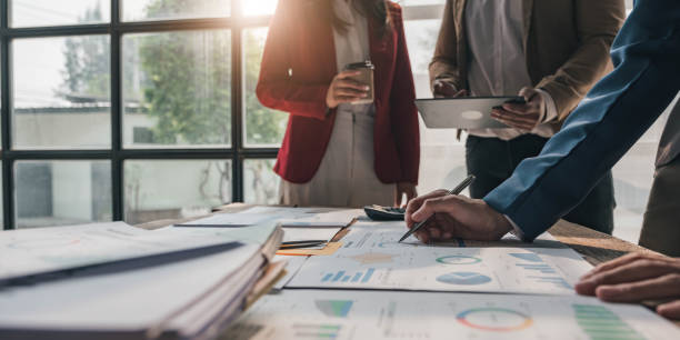istock Business People Meeting using laptop computer,calculator,notebook,stock market chart paper for analysis Plans to improve quality next month. Conference Discussion Corporate Concept. 1472132330