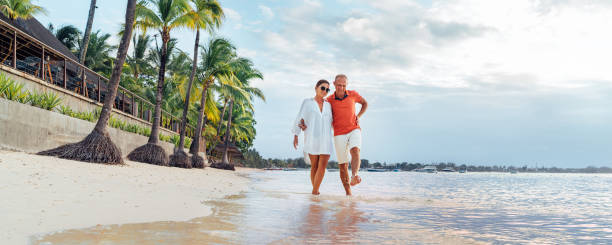 istock Couple in love hugging while walking on a sandy exotic beach. They have an evening walk by Trou-aux-Biches seashore on Mauritius island. People relationship and tropic honeymoon vacations concept 1472132332