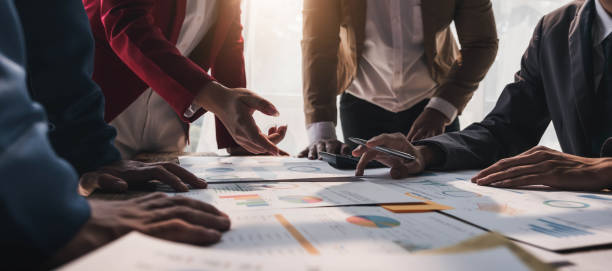 istock Business People Meeting using laptop computer,calculator,notebook,stock market chart paper for analysis Plans to improve quality next month. Conference Discussion Corporate Concept. 1472132508