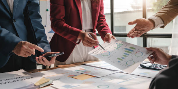 istock Business People Meeting using laptop computer,calculator,notebook,stock market chart paper for analysis Plans to improve quality next month. Conference Discussion Corporate Concept. 1472132587