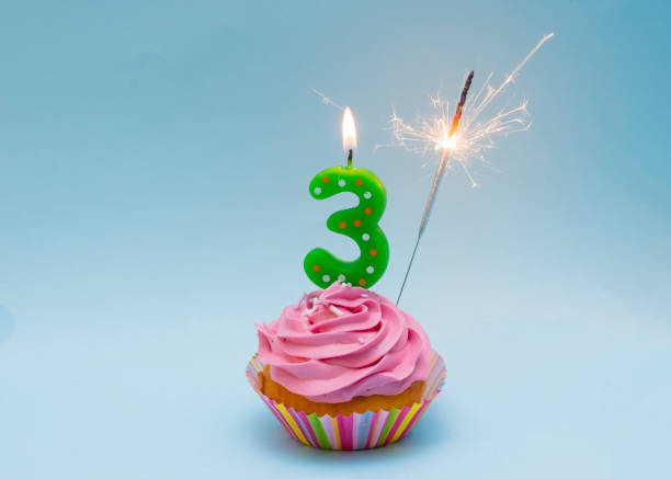 istock Happy Third Birthday Cupcake with 3 Candle and Sparkler 1472133894
