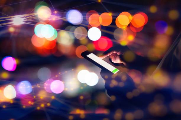 istock Man using smart phone with city lights in the background 1472133949