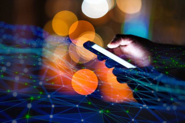 istock Man using smart phone with city lights in the background 1472133974