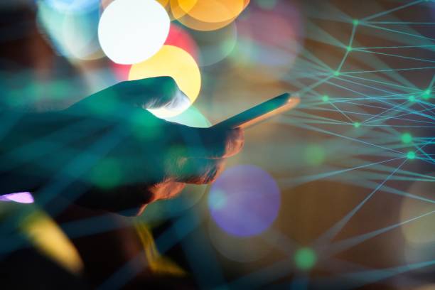 istock Man using smart phone with city lights in the background 1472134318