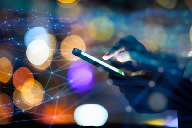 istock Man using smart phone with city lights in the background 1472134885