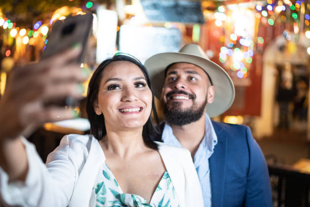 istock Couple taking a selfie using mobile phone outdoors 1472135402
