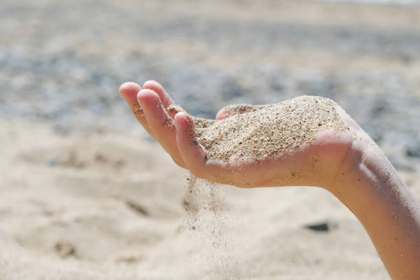 istock A young woman's hands hold sand on the beach. A natural summer background. 1472135585