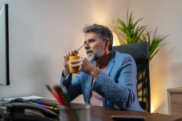 istock Mature man drinking coffee in office 1472139508