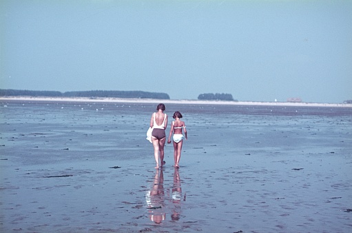 Foehr, Frisian Islands, Northern Germany, 1967. A mother and daughter walk across the mud flats at low tide off the coast of the holiday island of Foehr.