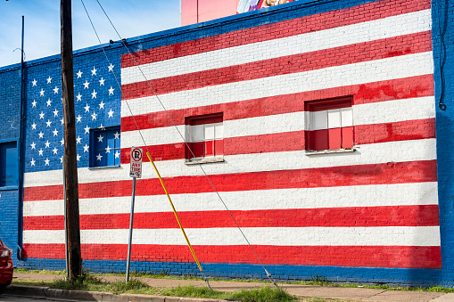 Dallas, Texas, USA - November 13, 2021:  Deep Ellum entertainment district painted American flag on the side of a building in the downtown core of the city of Dallas Texas USA he's known for a street murals, galleries, bars and concert venues