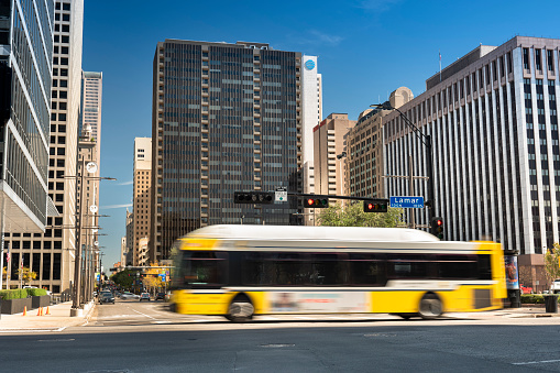 Dallas, Texas, USA - November 13, 2021: People and public transportation bus traffic move along the downtown city streets of Dallas Texas USA