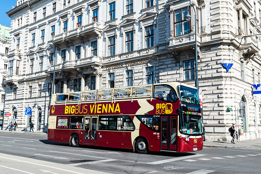 Vienna, Austria - October 18, 2022: Tour bus with tourists circulating with people around in Innere Stadt, Vienna, Austria