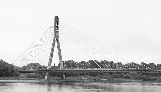 Concrete pylon with attached tie rods of Swietokrzyski cable-stayed bridge over Vistula river in Warsaw, black and white image