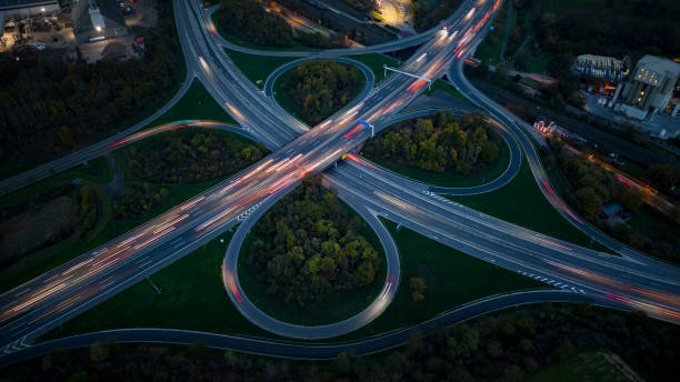 夕暮れ時の高速道路インターチェンジと工業地区 – 空撮 ストックフォト