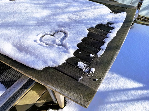 Heart shape drawn in snow a sunny winters day
