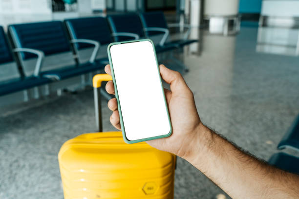 istock Using phone in travelling. Blank screen smartphone at the airport before the flight. Application for travel, banking, concept. 1472149710