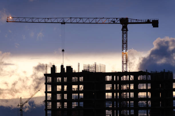 istock Tower crane, workers work at construction site. Process of building new houses 1472151532
