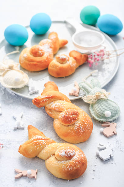 istock Easter baking - Buns made from yeast dough in a shape of Easter bunny and colored eggs 1472152034