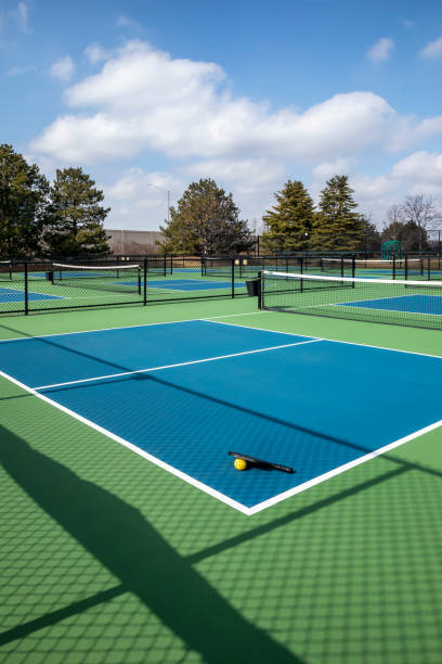 istock Pickleball Court Complex with Paddle and Yellow Ball 1472159951