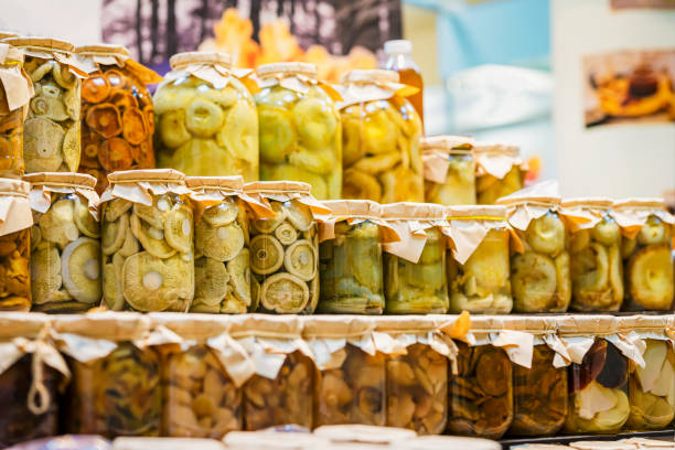 Glass jar rows with marinated, salted mushrooms, prepared by farmer. Soft selective focus. Preserving Organic Vegetables