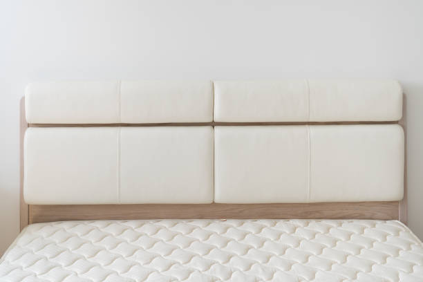 White natural leather bed headboard. Oak wood bed with mattress.