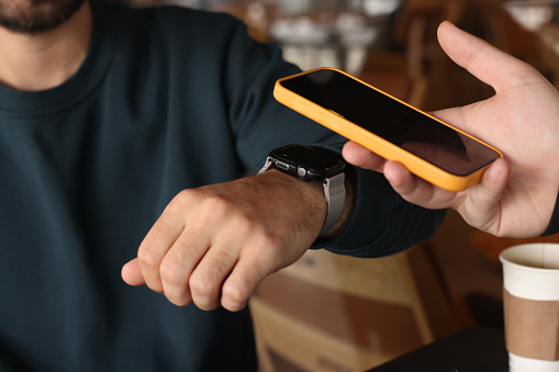 Man making NFC payment with his smart watch