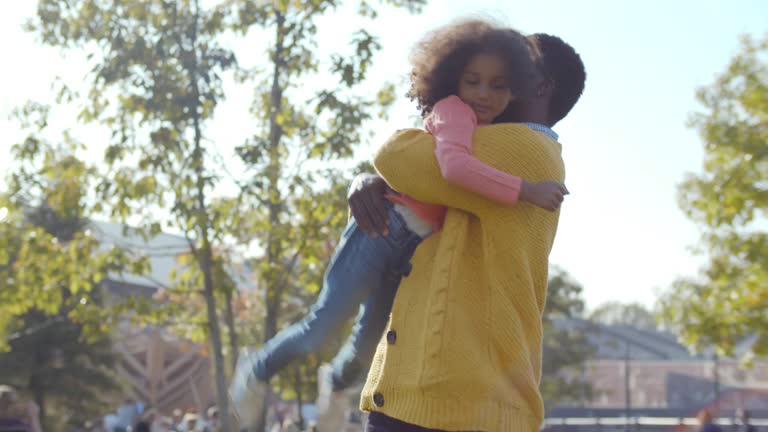 African-American father and daughter play in park. Realtime