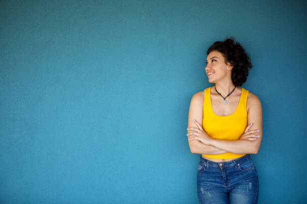 Cute young woman posing against a blue background