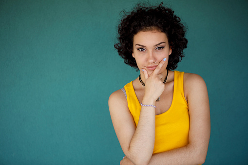 Portrait of attractive young woman against green background