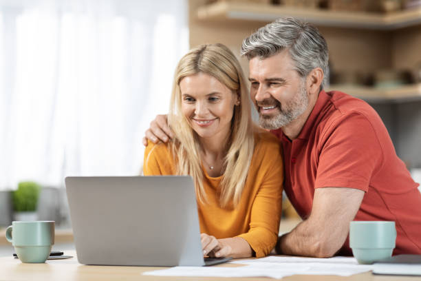 istock Loving couple paying bills on Internet together 1472174998
