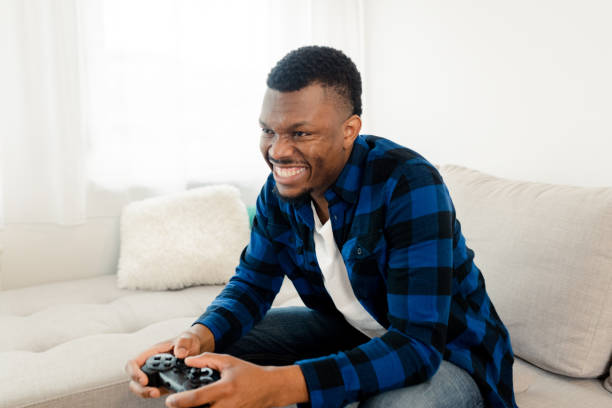 istock Young man gaming and having fun at home 1472177960