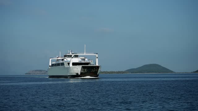 Cinematic shot of ferry boat sailing on sea line from mainland to island in Greece