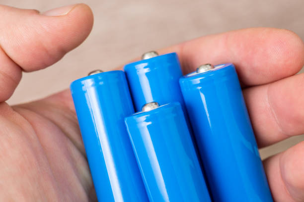 istock Man with 4 blue accumulators in his hand 1472180582