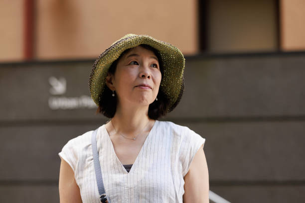 istock Japanese woman with hat outdoors looking up 1472183327
