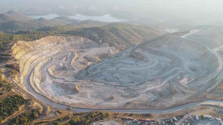 Aerial view of opencast mining quarry with lots of machinery at work - view from above