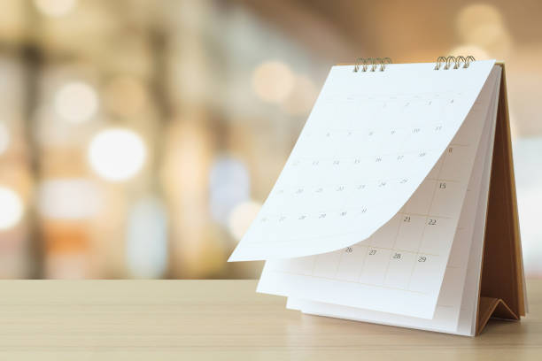 calendario de escritorio sobre mesa con bokeh borroso concepto de cita de fondo y reunión de negocios - calendario fotografías e imágenes de stock